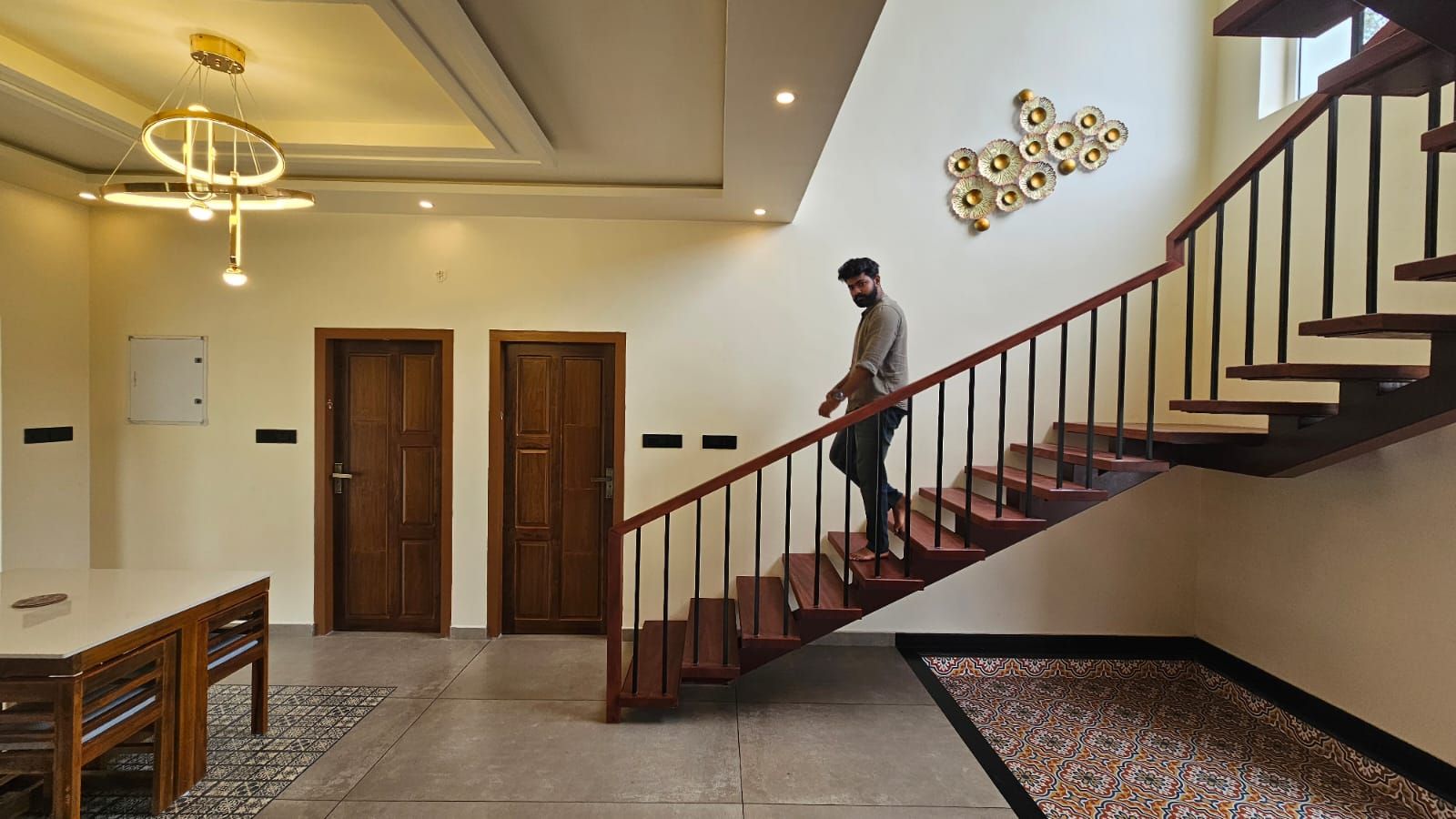 Spacious dining area adjacent to the main staircase, featuring modern gold ring chandeliers and a seamless flow between the dining and circulation zones.